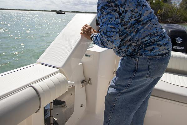 Slide: The Image of Person on a 2023 Sea Born LX26 boat adjusting a seat near the water. - 13