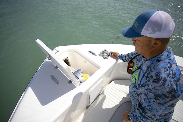 Slide: The Image of Man on 2023 Sea Born LX26 boat inspecting storage compartment. - 31