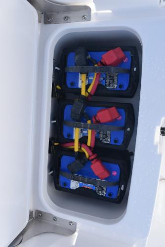 Slide: The Image of 2025 Sea Cat 26 Hybrid Catamaran battery compartment with secured blue batteries. - 25