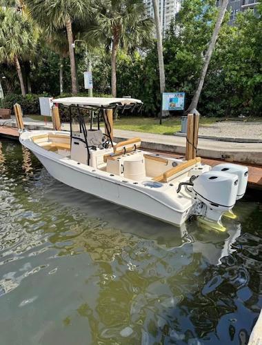 Slide: The Image of 2024 Sea Chaser 24 HFC boat docked in a scenic marina setting. - 0