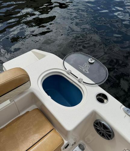 Slide: The Image of 2024 Sea Chaser 24 HFC boat with open storage compartment by the water. - 11