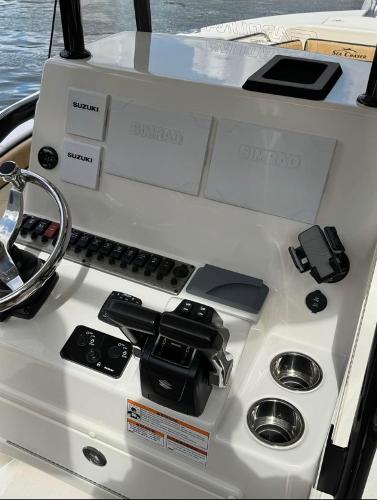 Slide: The Image of 2024 Sea Chaser 24 HFC boat console with Suzuki controls and Simrad displays. - 7