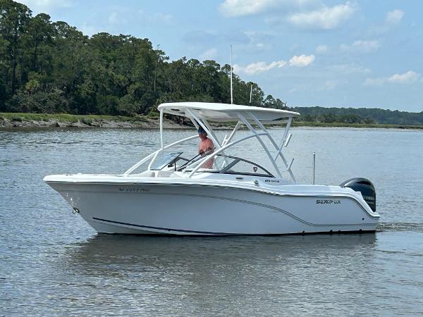 Slide: The Image of 2024 Sea Fox 226 Traveler boat cruising on a calm river with lush greenery. - 1