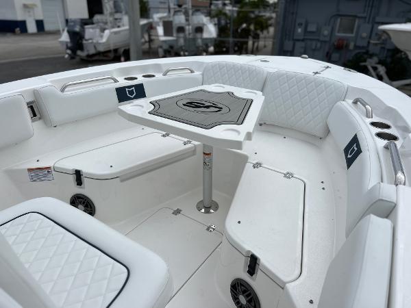 Slide: The Image of 2024 Sea Fox 228 Commander boat with white cushioned seating and a central table. - 9