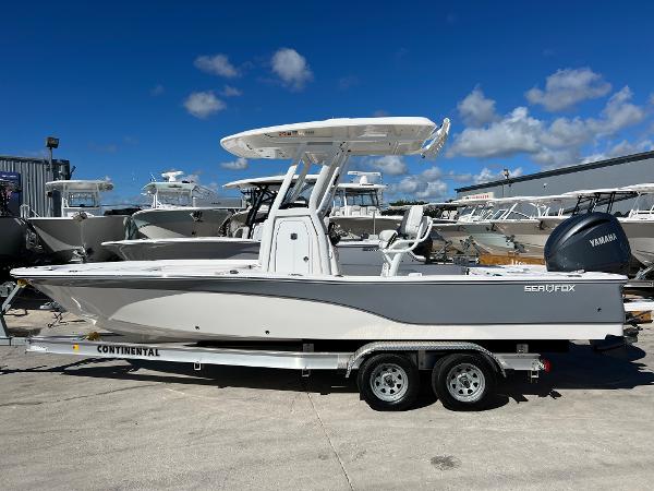Slide: The Image of 2024 Sea Fox 251 Bay Fox boat on a Continental trailer, docked outdoors. - 1