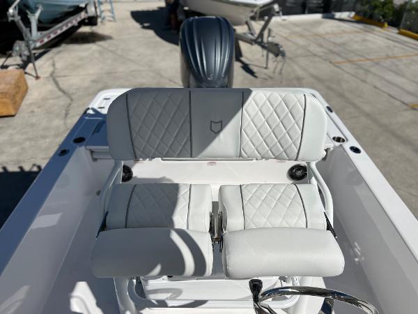 Slide: The Image of 2024 Sea Fox 251 Bay Fox boat with white cushioned seating and outboard motor. - 19