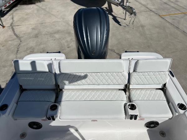 Slide: The Image of 2024 Sea Fox 251 Bay Fox boat with white cushioned seating and outboard motor. - 26