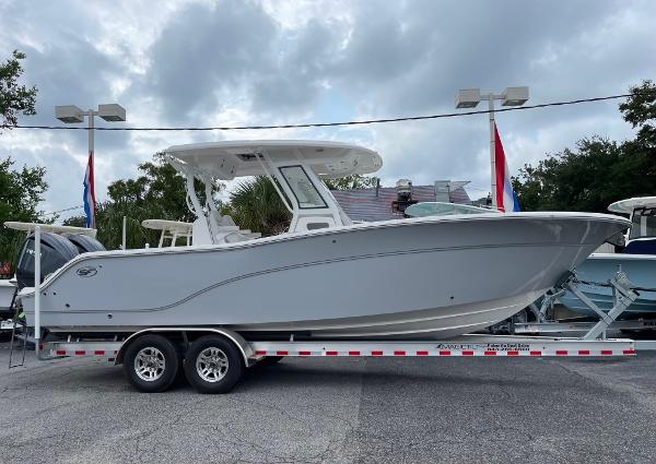 Slide: The Image of 2024 Sea Fox 288 Commander boat on a trailer, displayed outdoors under cloudy skies. - 0