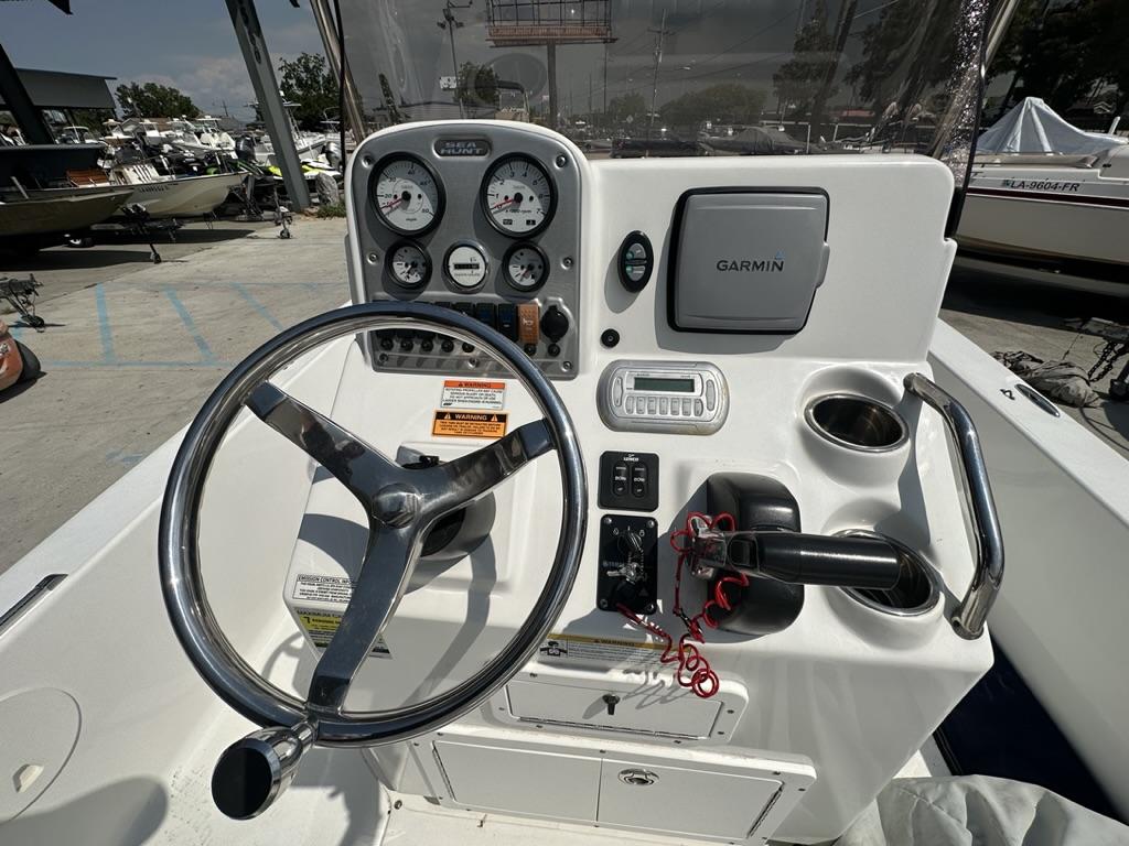 Slide: The Image of 2012 Sea Hunt BX 22 Pro boat dashboard with steering wheel, gauges, and Garmin navigation system. - 10