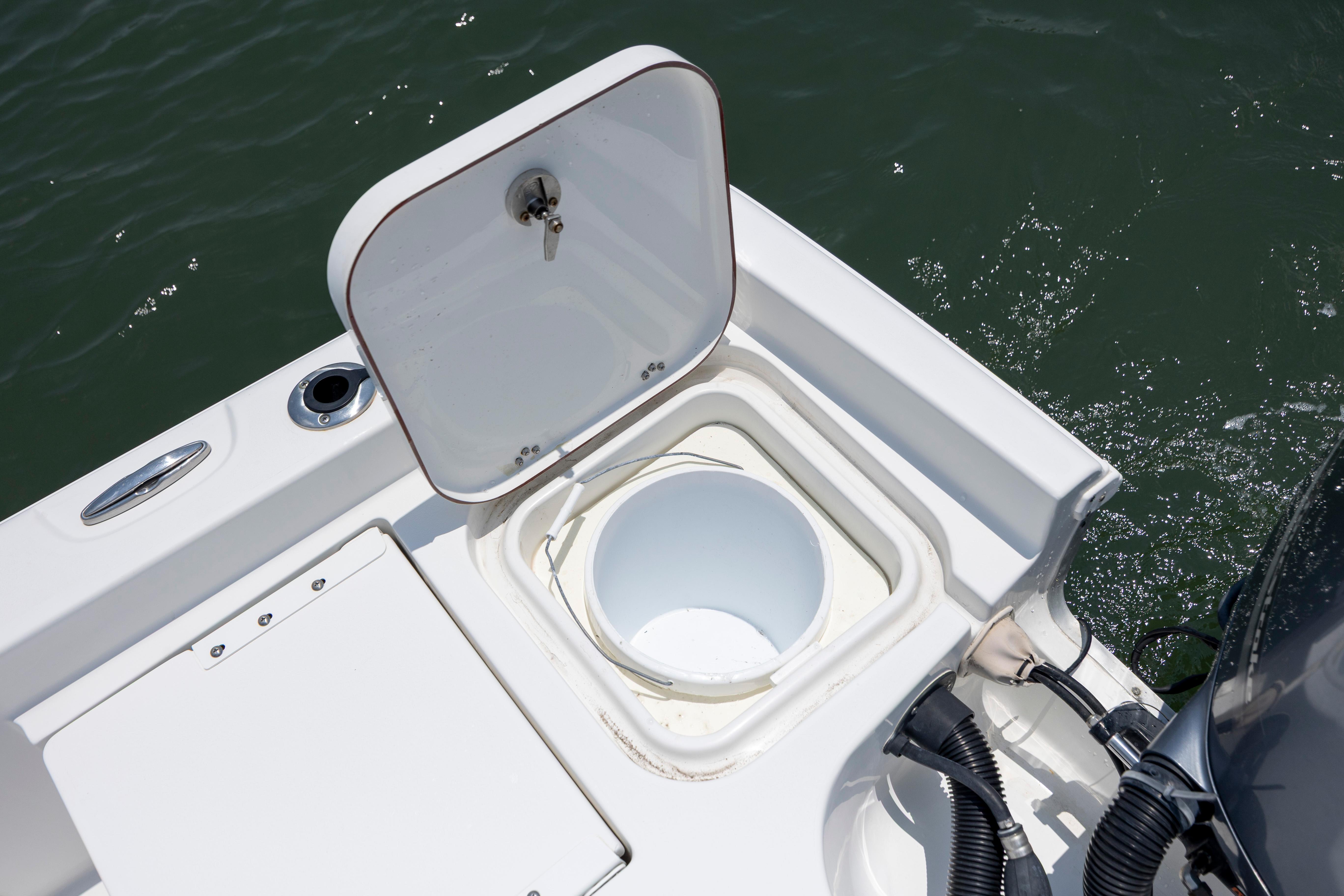 Slide: The Image of Open storage compartment on 2016 Sea Hunt BX 24 BR boat, near water. - 15