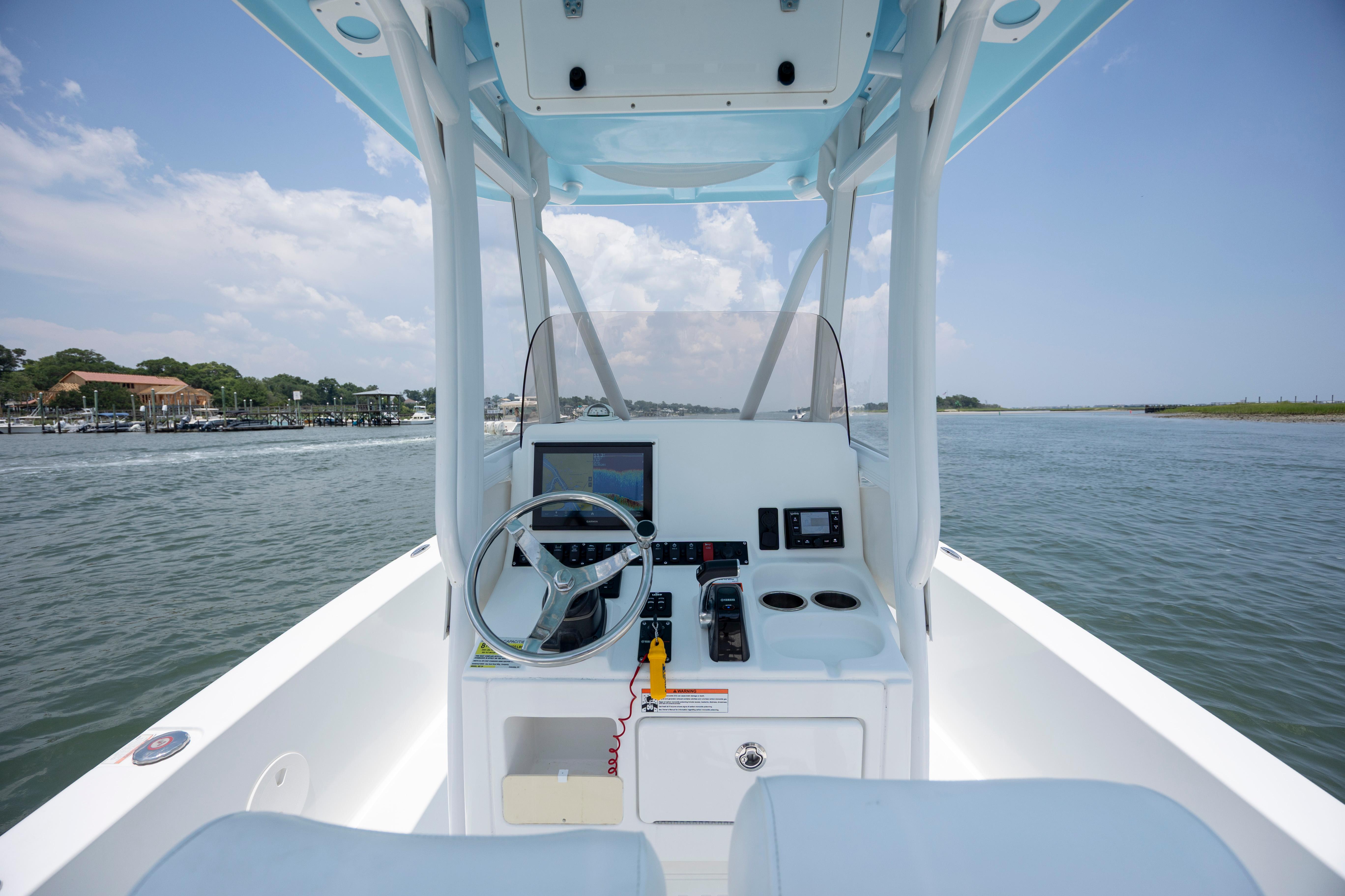 Slide: The Image of 2016 Sea Hunt BX 24 BR boat console with steering wheel and navigation equipment on open water. - 18