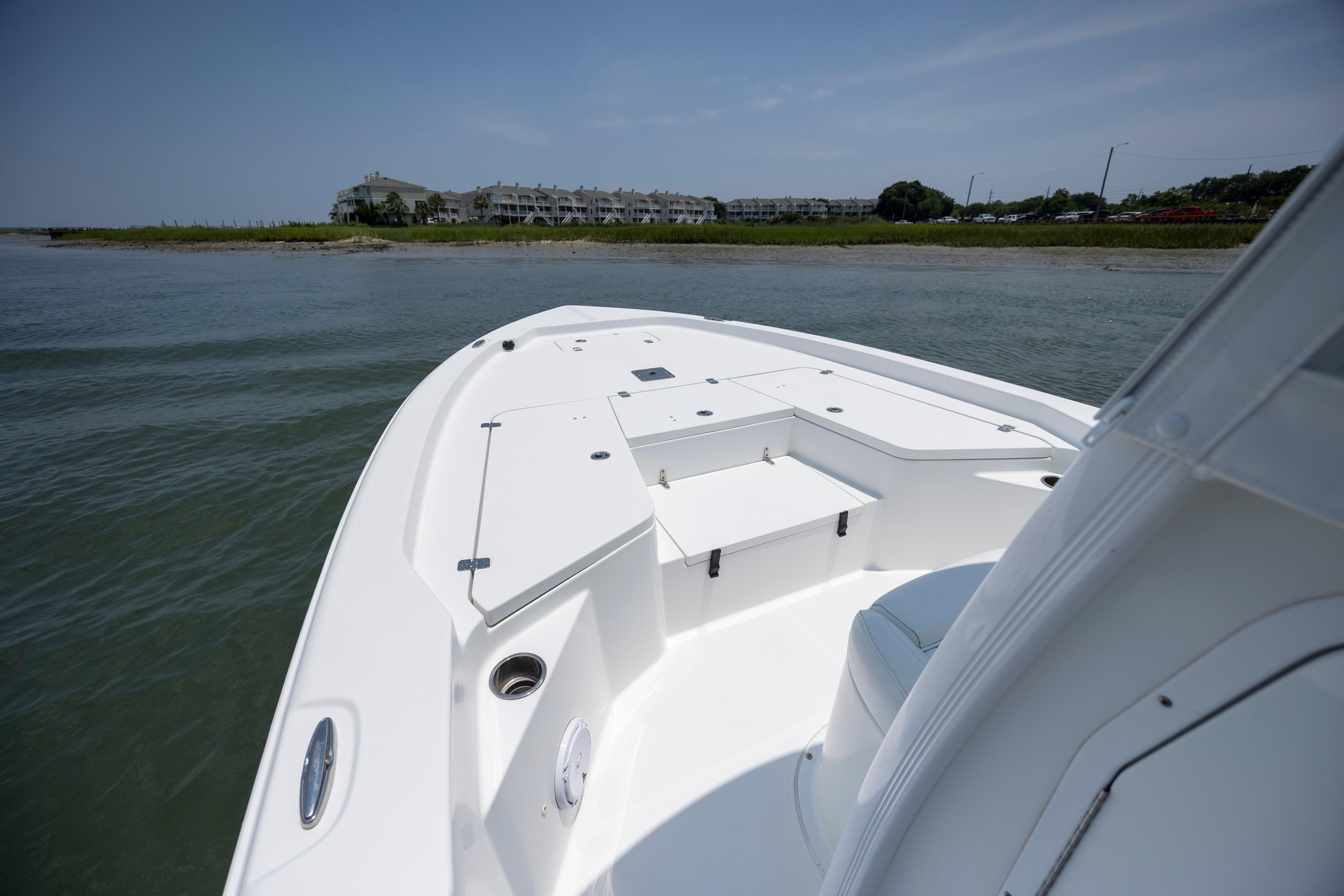 Slide: The Image of 2016 Sea Hunt BX 24 BR boat on calm water near shoreline. - 24