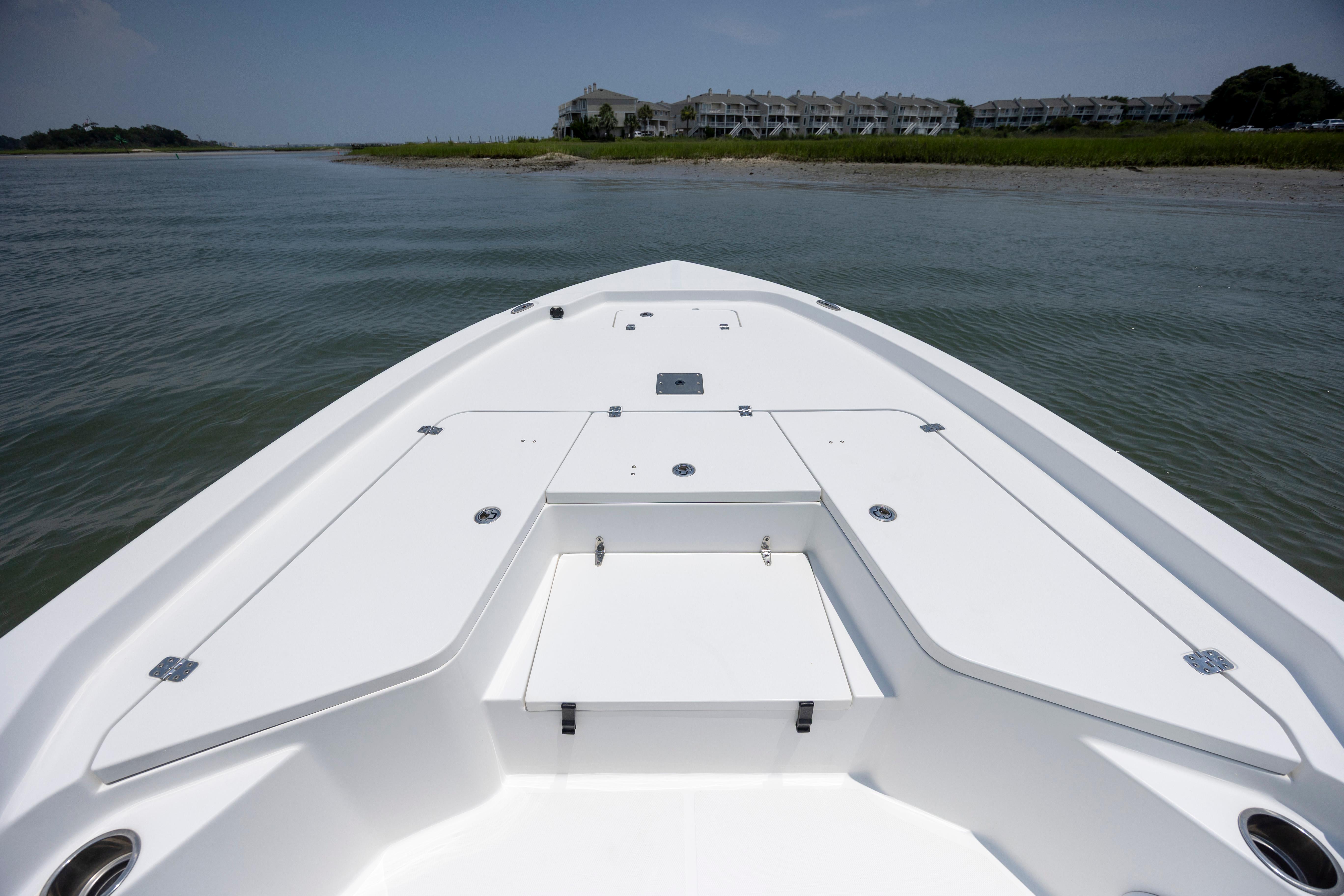 Slide: The Image of 2016 Sea Hunt BX 24 BR boat on calm water near shoreline with buildings. - 25