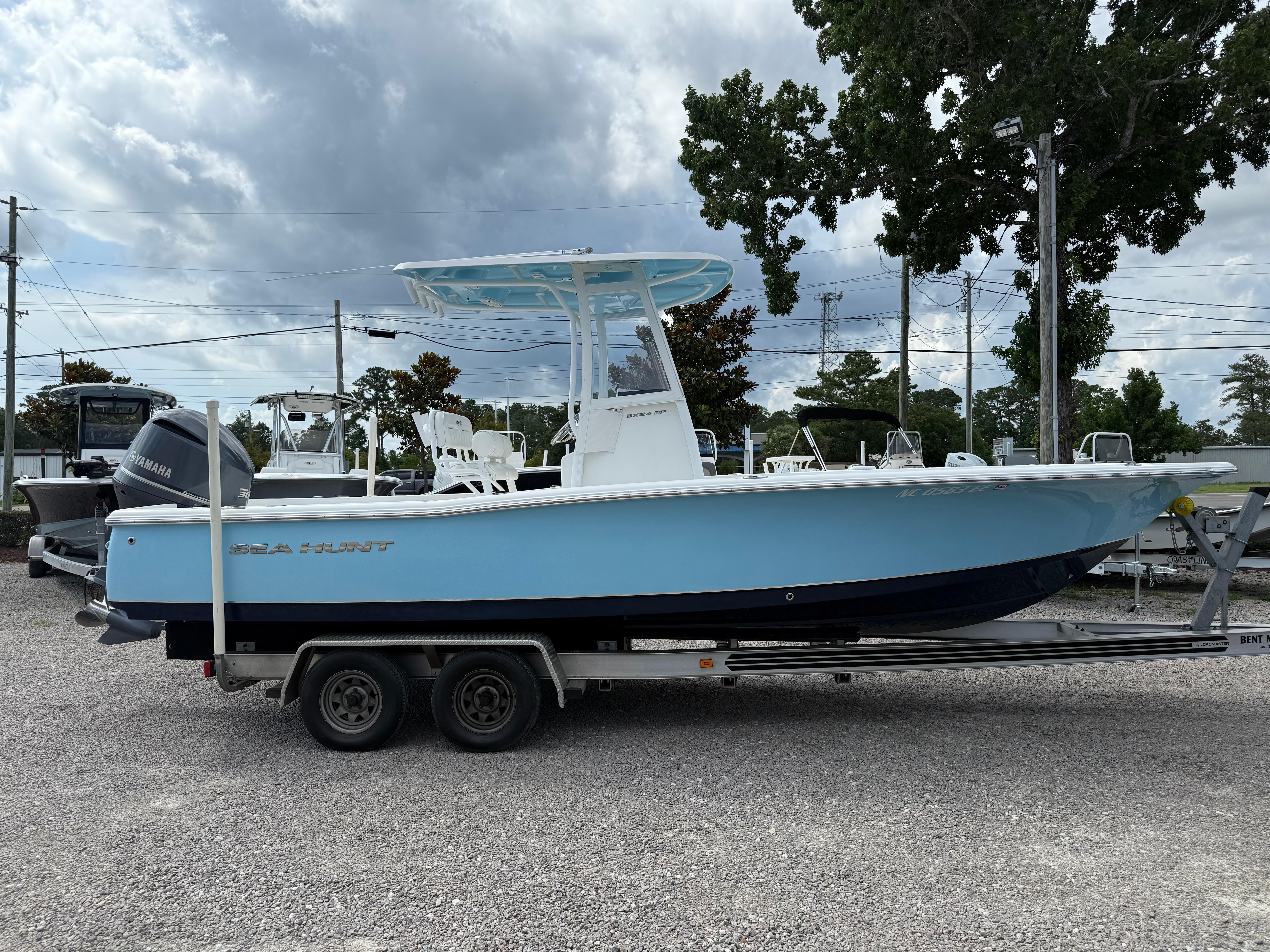 Slide: The Image of 2016 Sea Hunt BX 24 BR boat on trailer, parked outdoors under cloudy sky. - 33
