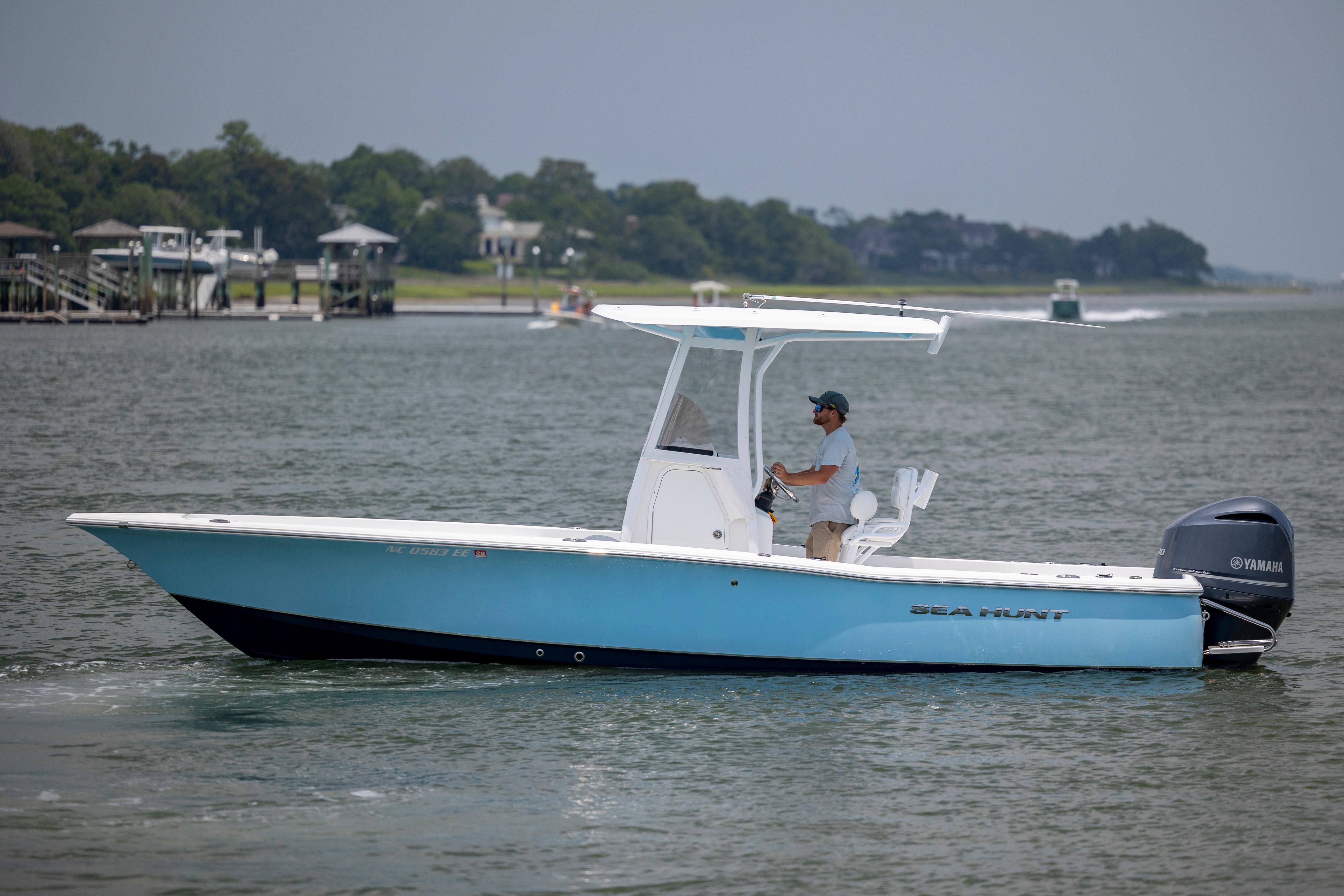 Slide: The Image of 2016 Sea Hunt BX 24 BR boat cruising on a calm waterway. - 6