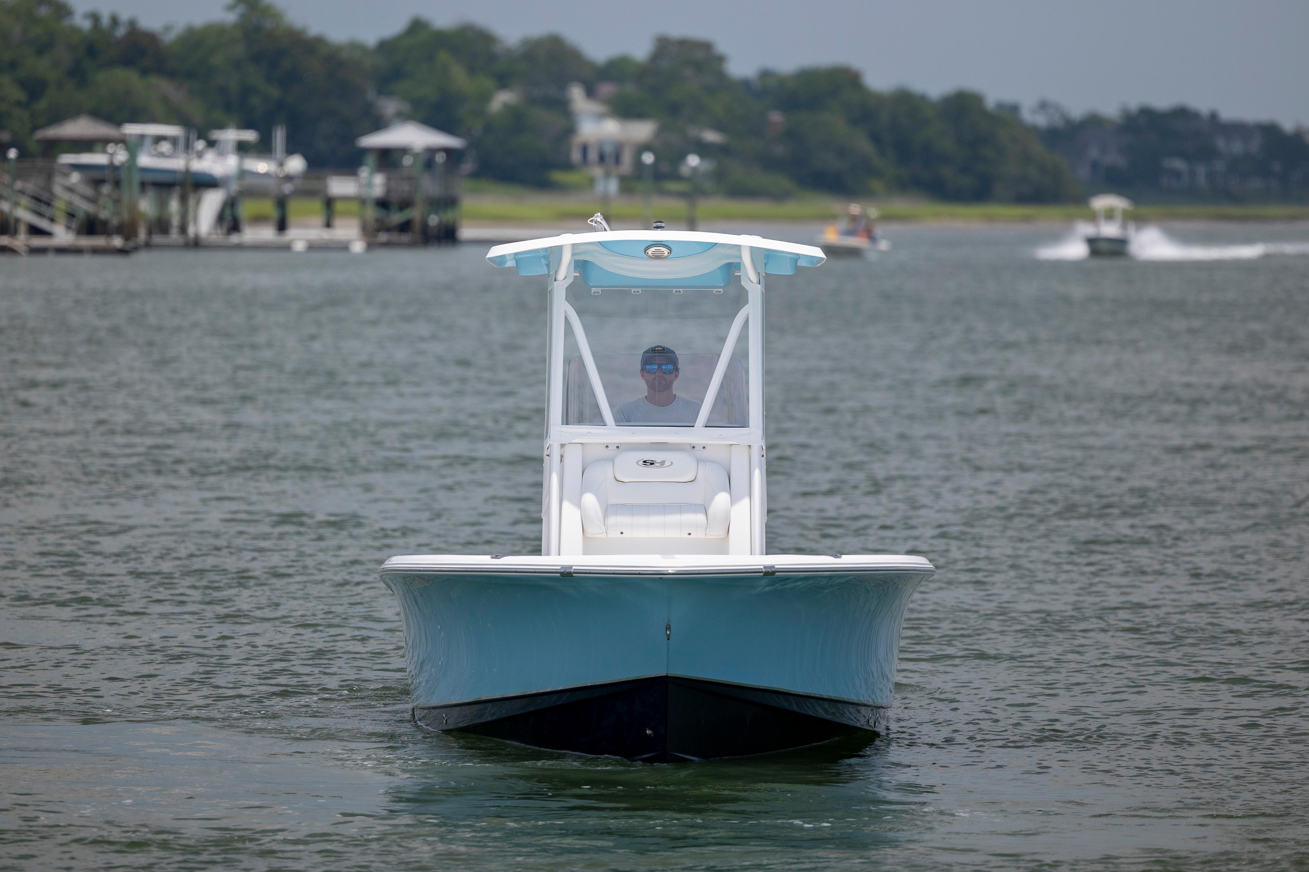 Slide: The Image of 2016 Sea Hunt BX 24 BR boat cruising on a calm waterway. - 8