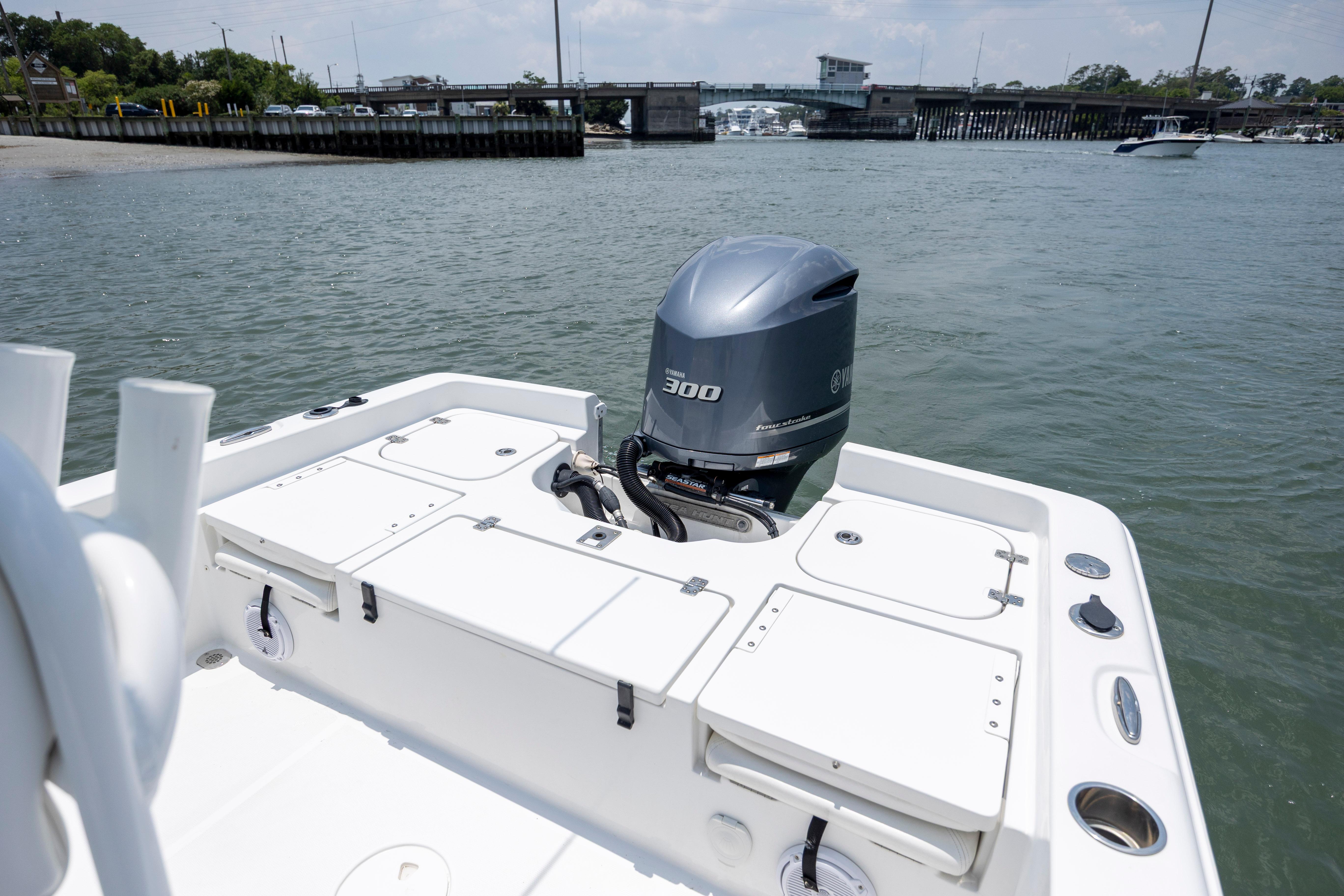 Slide: The Image of 2016 Sea Hunt BX 24 BR boat with Yamaha 300 engine on calm water near a bridge. - 9