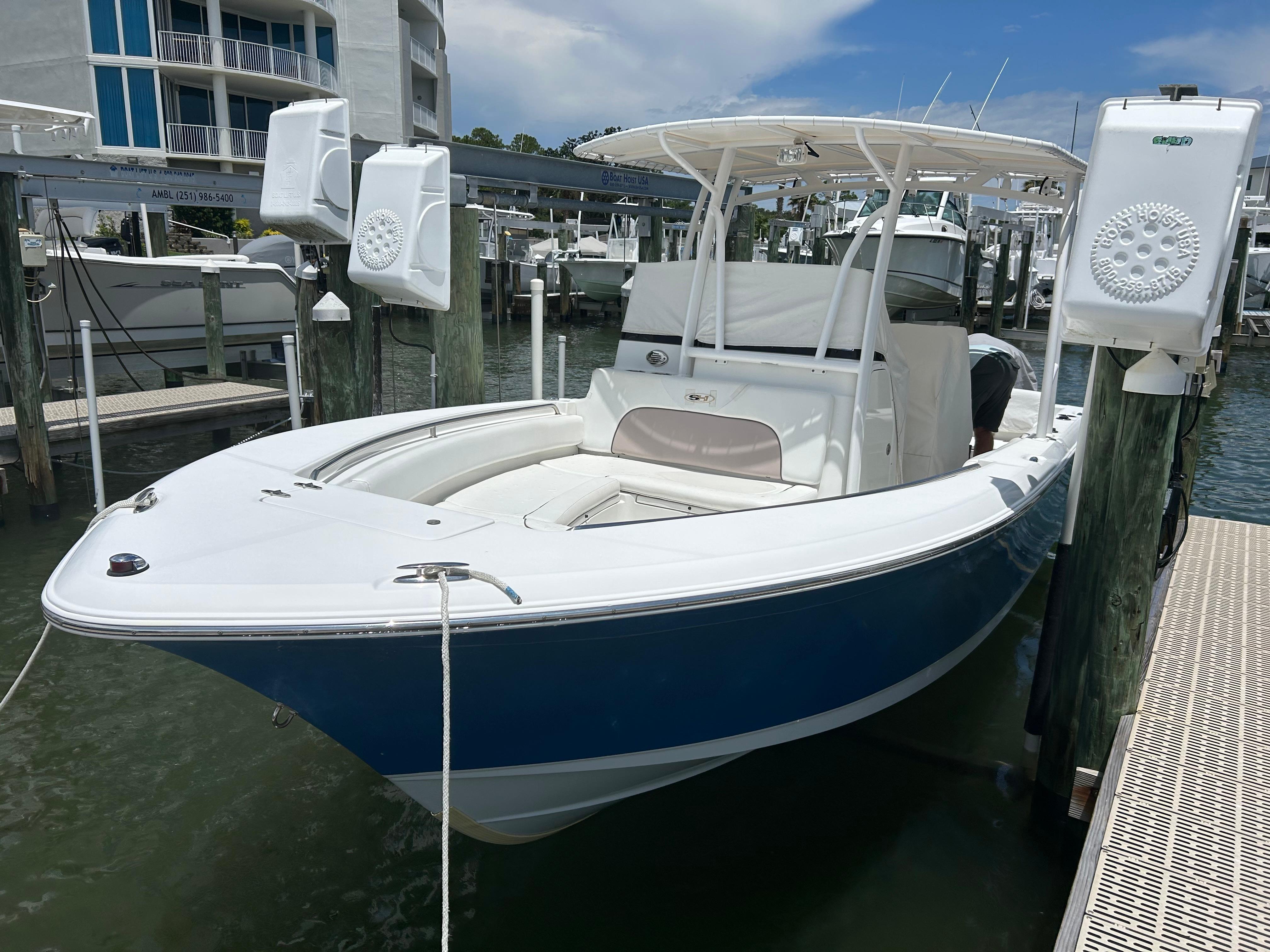 Slide: The Image of 2013 Sea Hunt Edge 24 boat docked at marina, featuring sleek design and spacious seating. - 1