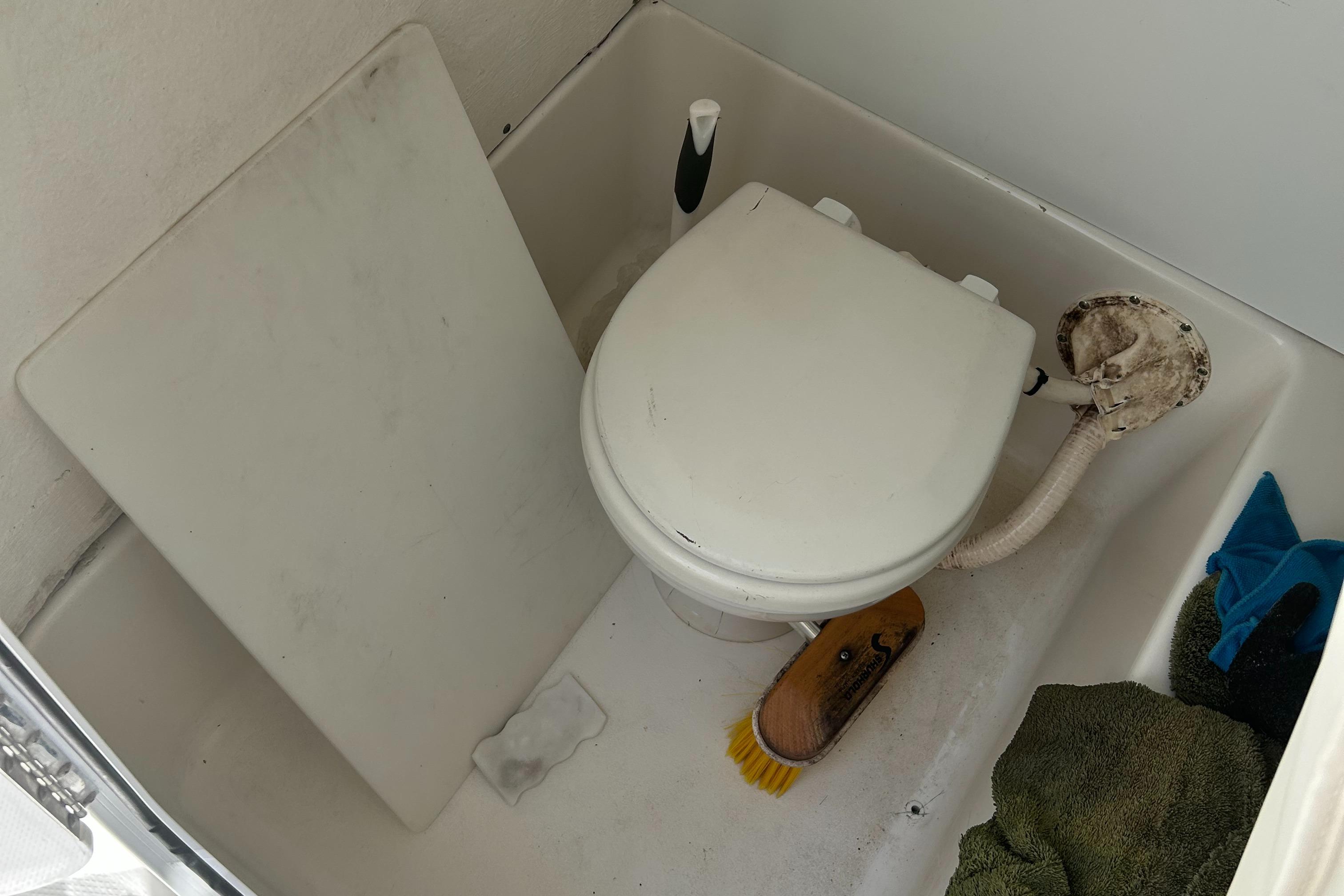 Slide: The Image of Boat bathroom with toilet and cleaning supplies on a 2013 Sea Hunt Edge 24. - 14