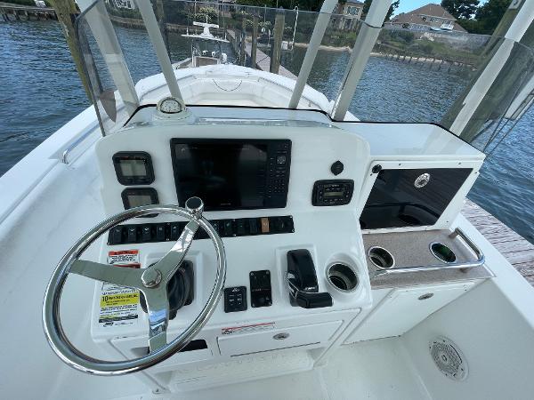 Slide: The Image of 2015 Sea Hunt Edge 24 boat console with steering wheel, controls, and navigation system. - 1