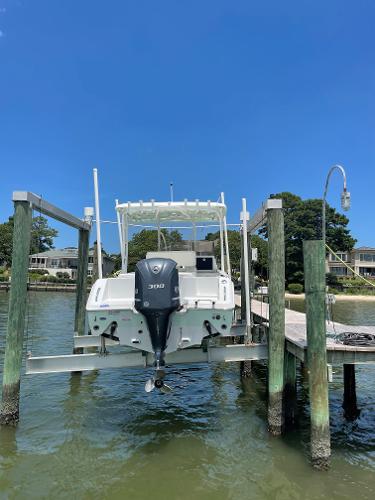 Slide: The Image of 2015 Sea Hunt Edge 24 boat on a lift at a dock. - 14
