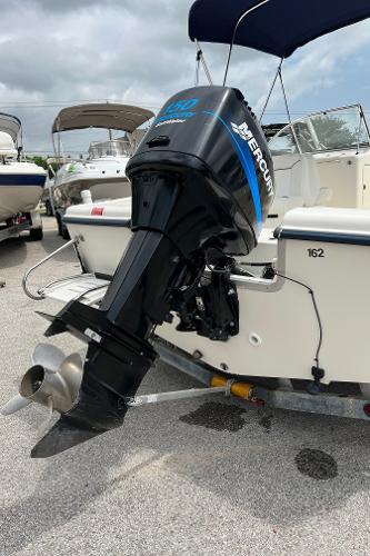 Slide: The Image of 2000 Sea Hunt Escape 200 boat with Mercury outboard motor, parked on a trailer. - 23