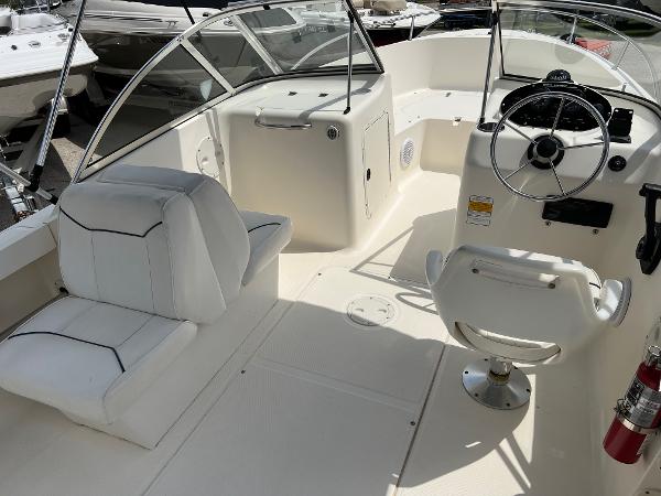 Slide: The Image of 2000 Sea Hunt Escape 200 boat interior with white seating and steering console. - 8