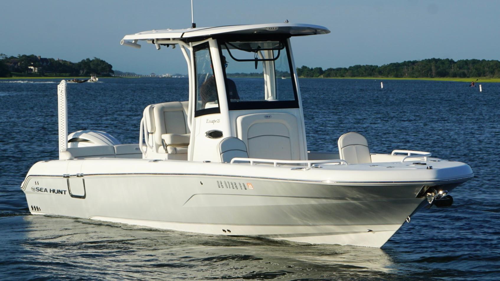 Slide: The Image of 2023 Sea Hunt Escape 25 boat cruising on a calm lake. - 2