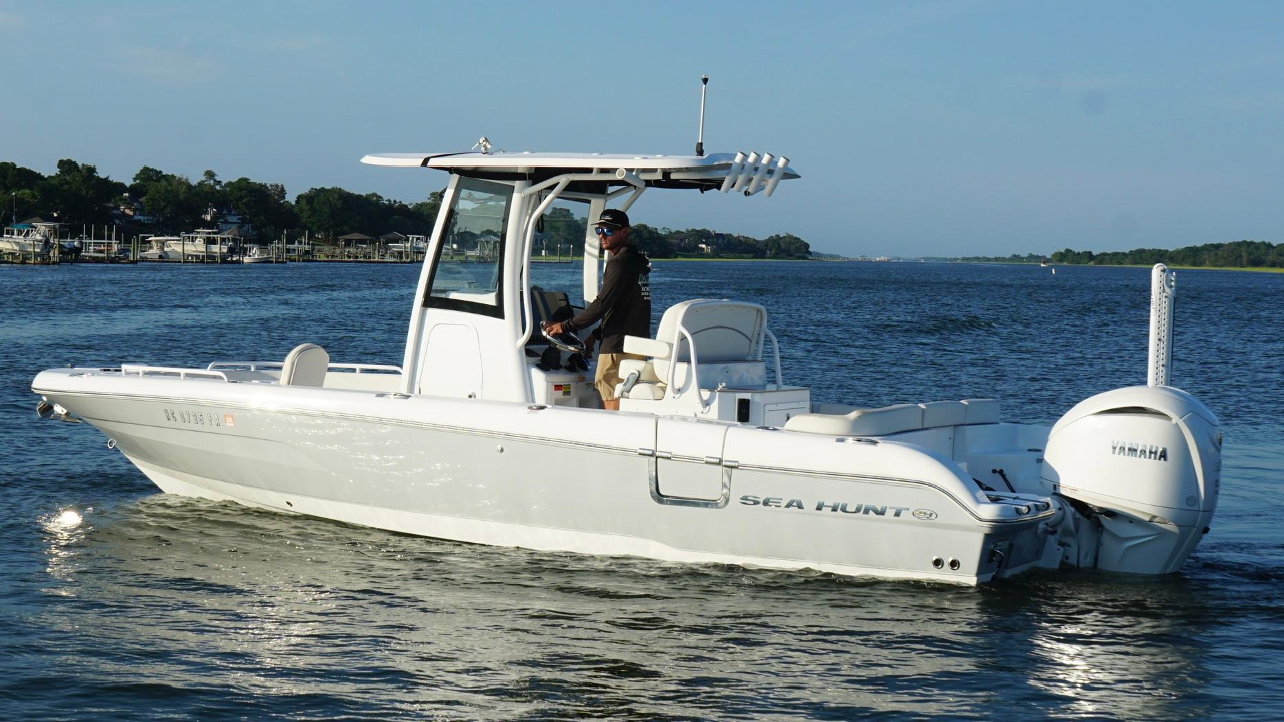 Slide: The Image of 2023 Sea Hunt Escape 25 boat cruising on a calm lake with Yamaha engine. - 5
