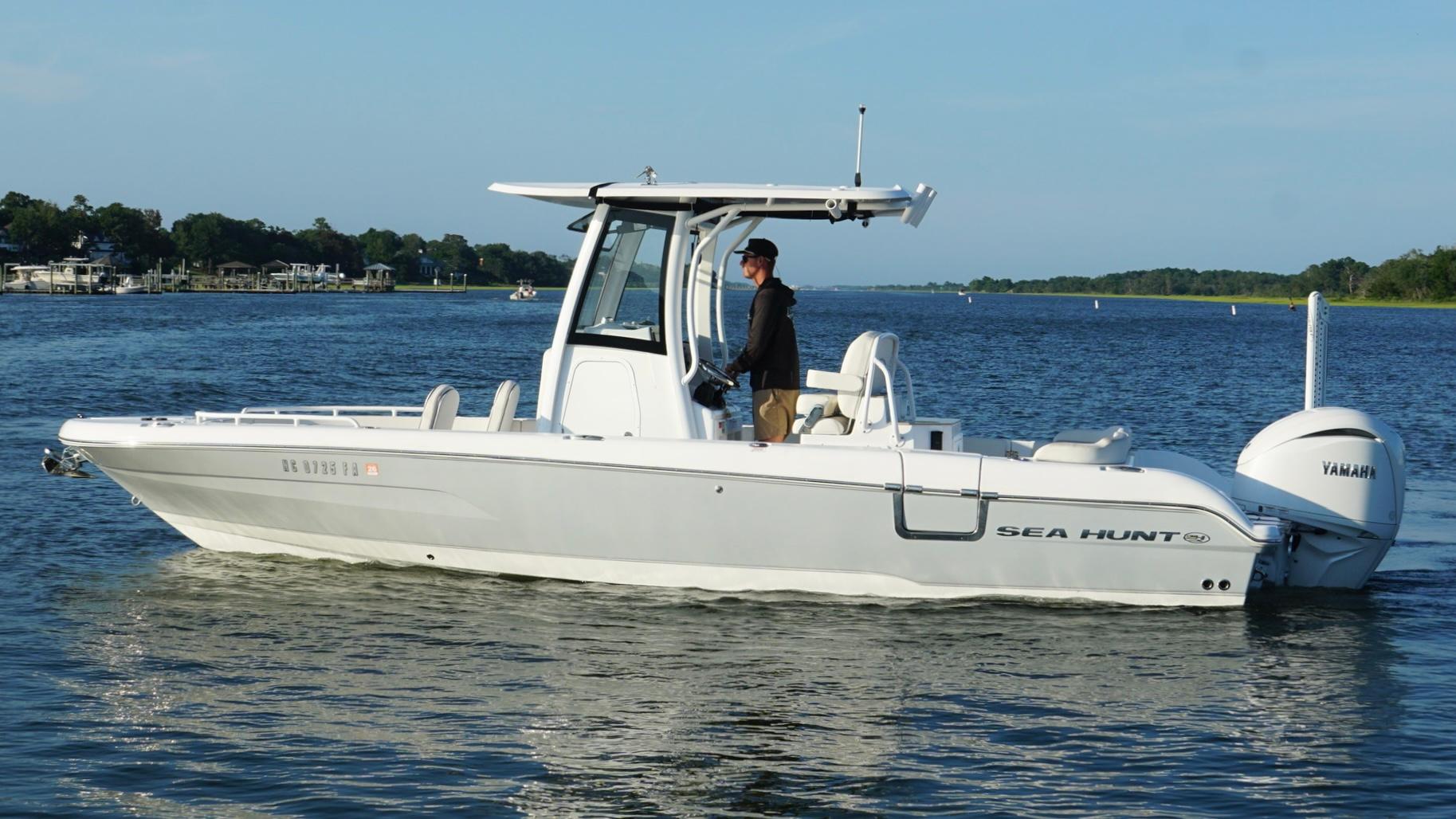 Slide: The Image of 2023 Sea Hunt Escape 25 boat cruising on a calm lake with a Yamaha engine. - 7