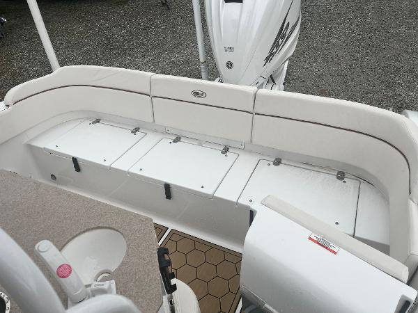 Slide: The Image of 2022 Sea Hunt Escape 27 boat interior with white seating and storage compartments. - 9