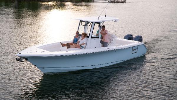 Slide: The Image of 2025 Sea Hunt Gamefish 27 Coffin Box boat cruising on calm water at sunset. - 1