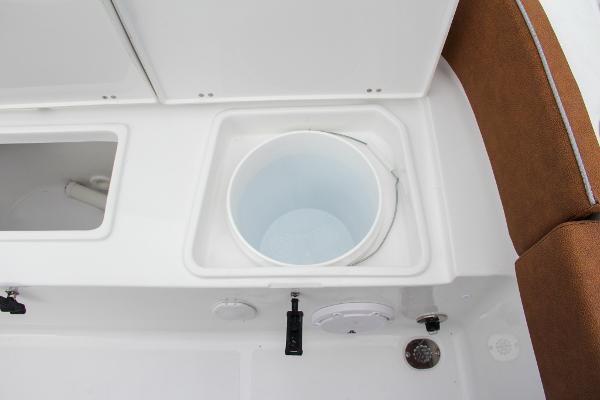 Slide: The Image of 2024 Sea Hunt Ultra 234 boat interior with storage compartments and bucket. - 13