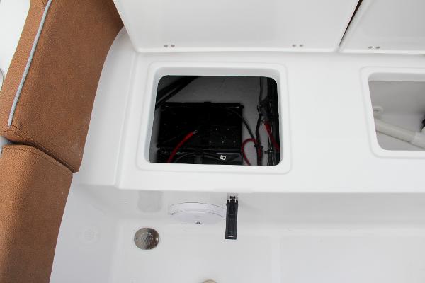 Slide: The Image of 2024 Sea Hunt Ultra 234 boat battery compartment with brown seating. - 15