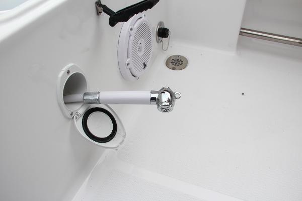 Slide: The Image of 2024 Sea Hunt Ultra 234 boat deck with a retractable shower head and speaker. - 17