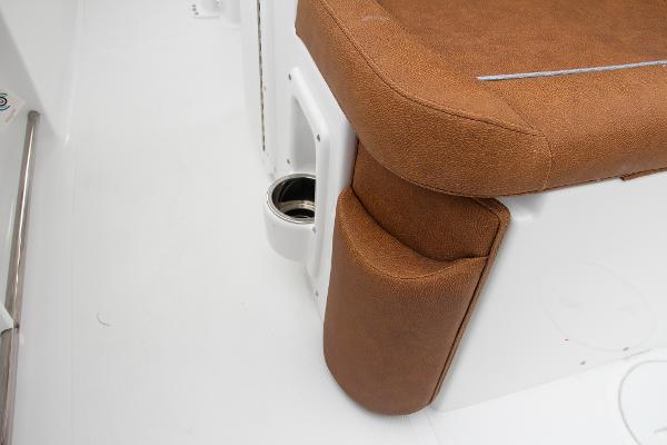 Slide: The Image of 2024 Sea Hunt Ultra 234 boat seat with brown upholstery and cup holder. - 25