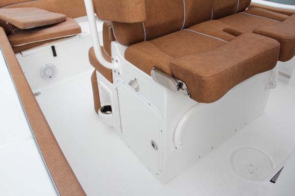 Slide: The Image of 2024 Sea Hunt Ultra 234 boat interior with brown cushioned seating and white deck. - 30