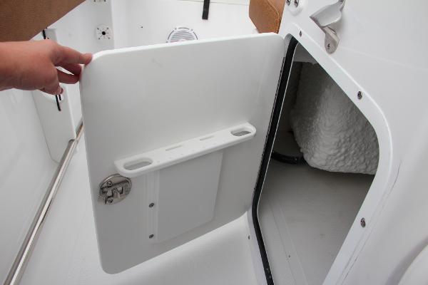 Slide: The Image of 2024 Sea Hunt Ultra 234 storage compartment with open door. - 31