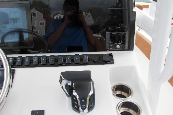 Slide: The Image of Control panel of 2024 Sea Hunt Ultra 234 boat with throttle and cup holders. - 38