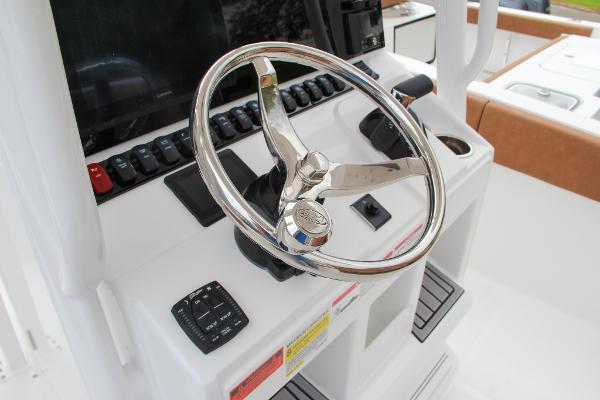 Slide: The Image of 2024 Sea Hunt Ultra 234 boat helm with stainless steel steering wheel and control panel. - 40