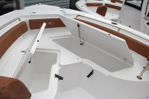 Slide: The Image of 2024 Sea Hunt Ultra 234 boat with open storage compartments. - 45