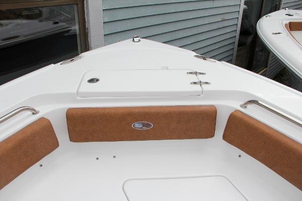 Slide: The Image of 2024 Sea Hunt Ultra 234 boat bow with cushioned seating and storage compartment. - 48