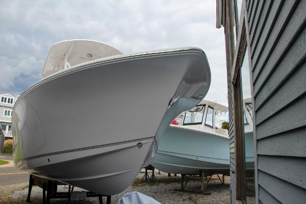 Slide: The Image of 2024 Sea Hunt Ultra 234 boat on display near a building. - 5
