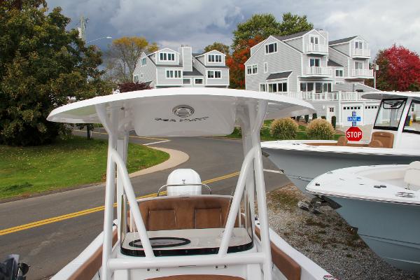Slide: The Image of 2024 Sea Hunt Ultra 234 boat docked near residential area with trees and houses. - 51