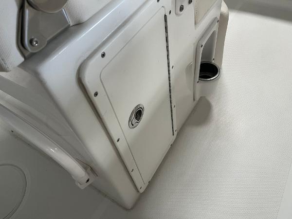 Slide: The Image of 2024 Sea Hunt Ultra 239 SE boat storage compartment and cup holder. - 11