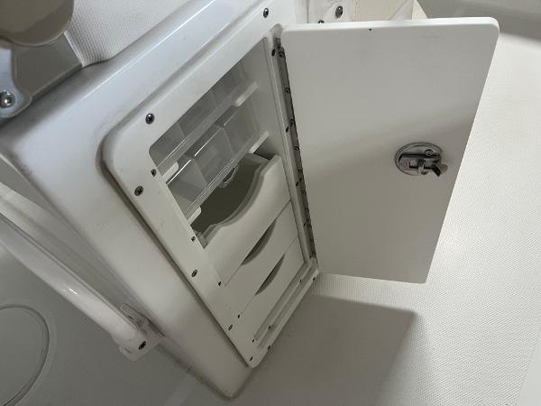 Slide: The Image of Open storage compartment on a 2024 Sea Hunt Ultra 239 SE boat. - 13