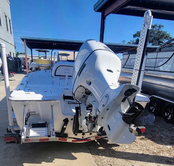 Slide: The Image of 2024 Sea Pro 172 Bay boat with outboard motor, docked under a canopy. - 4