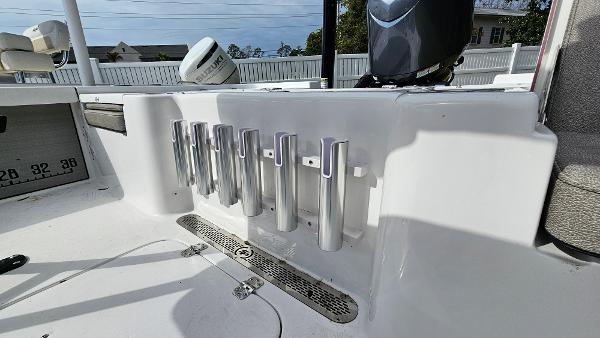 Slide: The Image of 2024 Sea Pro 210 Bay boat with rod holders and engine in the background. - 18