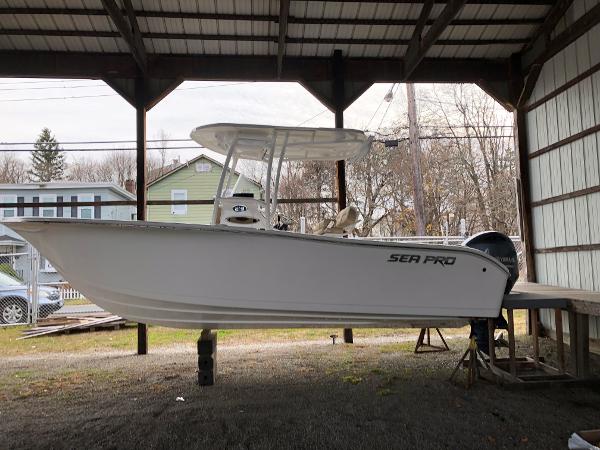 Slide: The Image of 2024 Sea Pro 219 Center Console boat under a covered structure. - 0