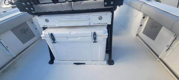 Slide: The Image of 2020 Sea Pro 239CC boat interior with storage compartments and cooler. - 12